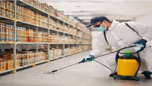 Commercial pest control technician spraying warehouse in Allen, TX